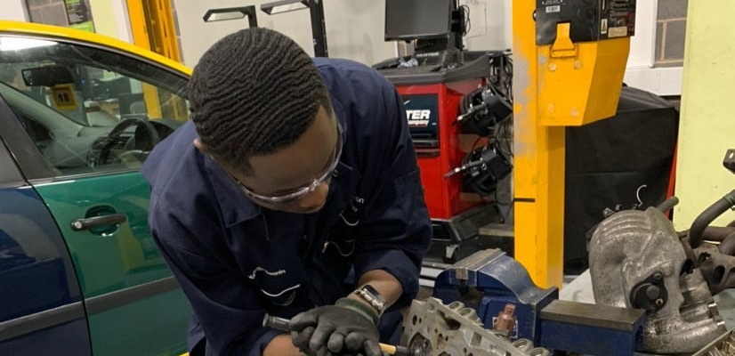 Kelvin working on a car in the workshop at Northampton College.