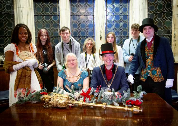 Students dressed in Bridgerton inspired costumes pose with the Mayor.