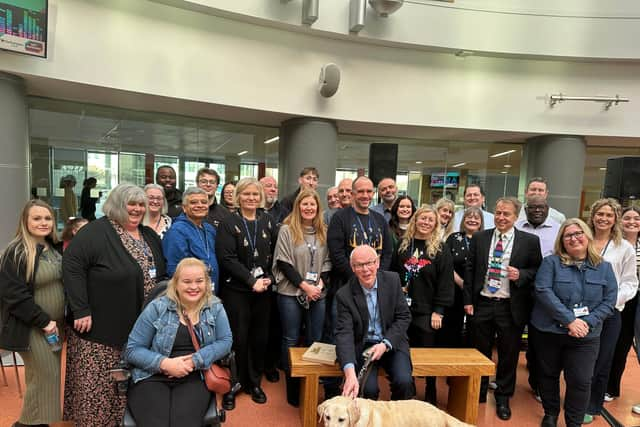 Patrick Leavey on his new bench surrounded by colleagues from Northampton College